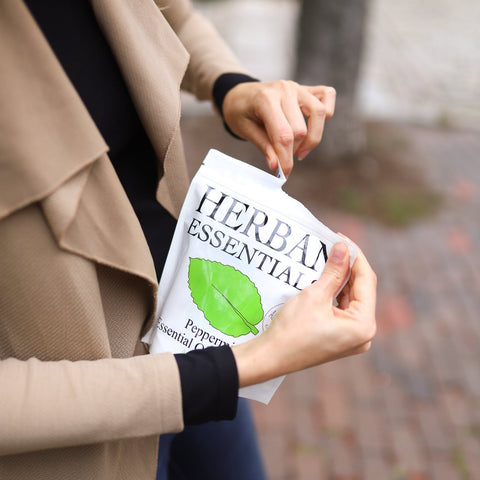 Girl opening a bag of Herban Essentials peppermint essential oil towelettes