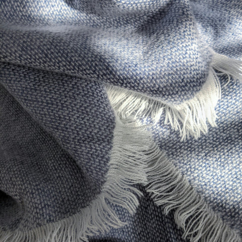 close-up of a lavender cashmere throw draped over a chair, its texture and color inviting quiet comfort and rest.