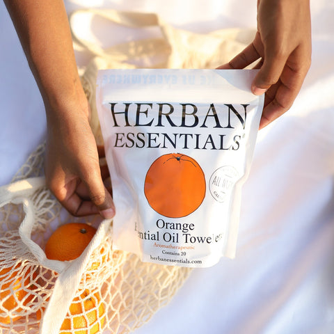 Herban Essentials Orange Essential Oil Towels held by a person on a white background