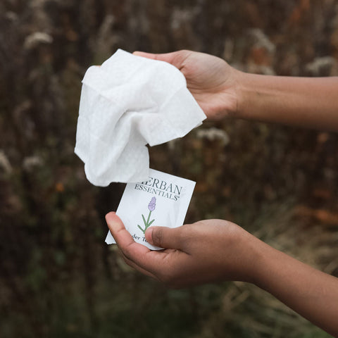 Person holding a packet of Herban Essentials lavender wipe with  a natural background