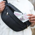 Person holding a black bag with Herban Essentials dog towelette.