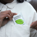 Person holding a Herban Essentials peppermint wipe in shirt pocket 
