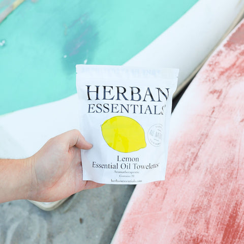 Person holding a Herban Essentials lemon essential oil towel by a poolside.