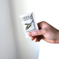 a single herban essentials eucalyptus essential oil towelette being held by a person